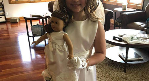 nicole's daughter and her doll wearing matching communion dresses made from her wedding dress